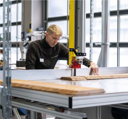 Ein Mitarbeiter an der Bandsäge Typ 3V Massivholz, ein Spezialgerät, das auch für sehr große Werkstücke geeignet ist.