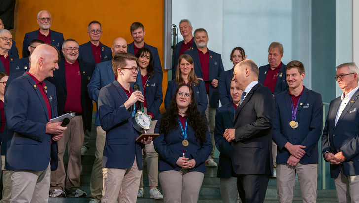 1  Zerspanungsmechaniker Tobias Rohrer (Exzellenzmedaille in der Disziplin CNC-­Fräsen) überreichte dem Bundeskanzler eine eigens angefer­tigte Uhr.