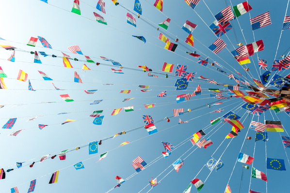Mehrere internationale Flaggen hängen an Schnüren vor einem klaren blauen Himmel. - © FrankBoston - stock.adobe.com
