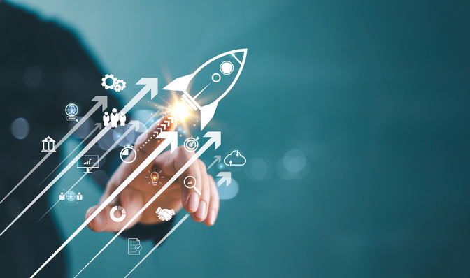 Hand, die auf eine stilisierte Rakete zeigt, die Unternehmenswachstum symbolisiert und von verschiedenen Erfolgssymbolen umgeben ist. - © MT.PHOTOSTOCK - stock.adobe.com
