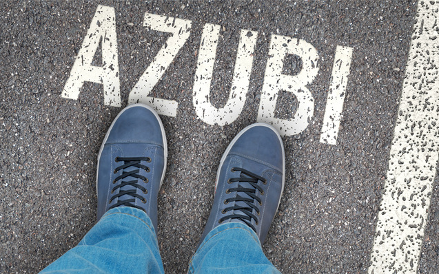 Person mit blauen Schuhen steht auf einem Bürgersteig, auf dem in Weiß das Wort „AZUBI“ aufgemalt ist. - © bluedesign - stock.adobe.com